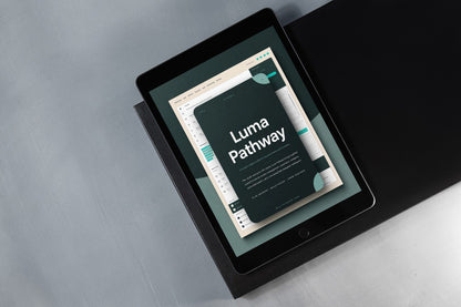A black tablet device angled on a dark surface, displaying a digital cover titled 'Luma Pathway' with a dark teal, cream, and white design.